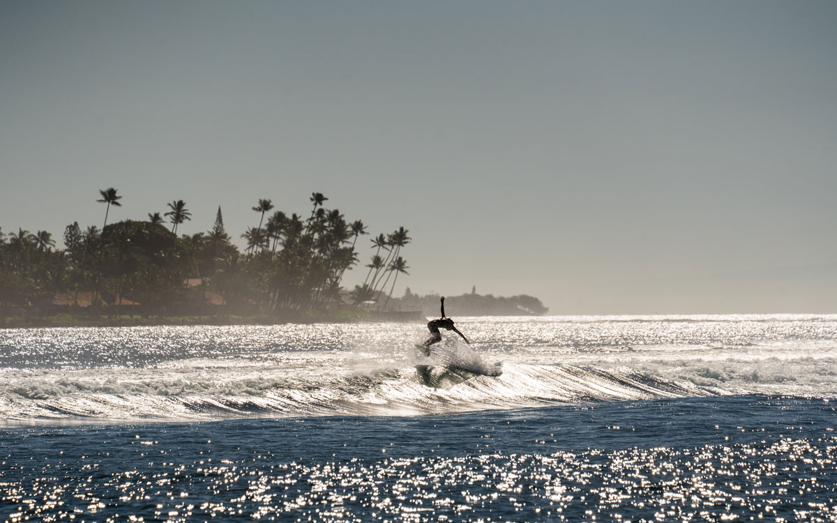 Ein Surfer auf einer Welle kurz vor der Einfahrt zum Hafen in Lahaina.