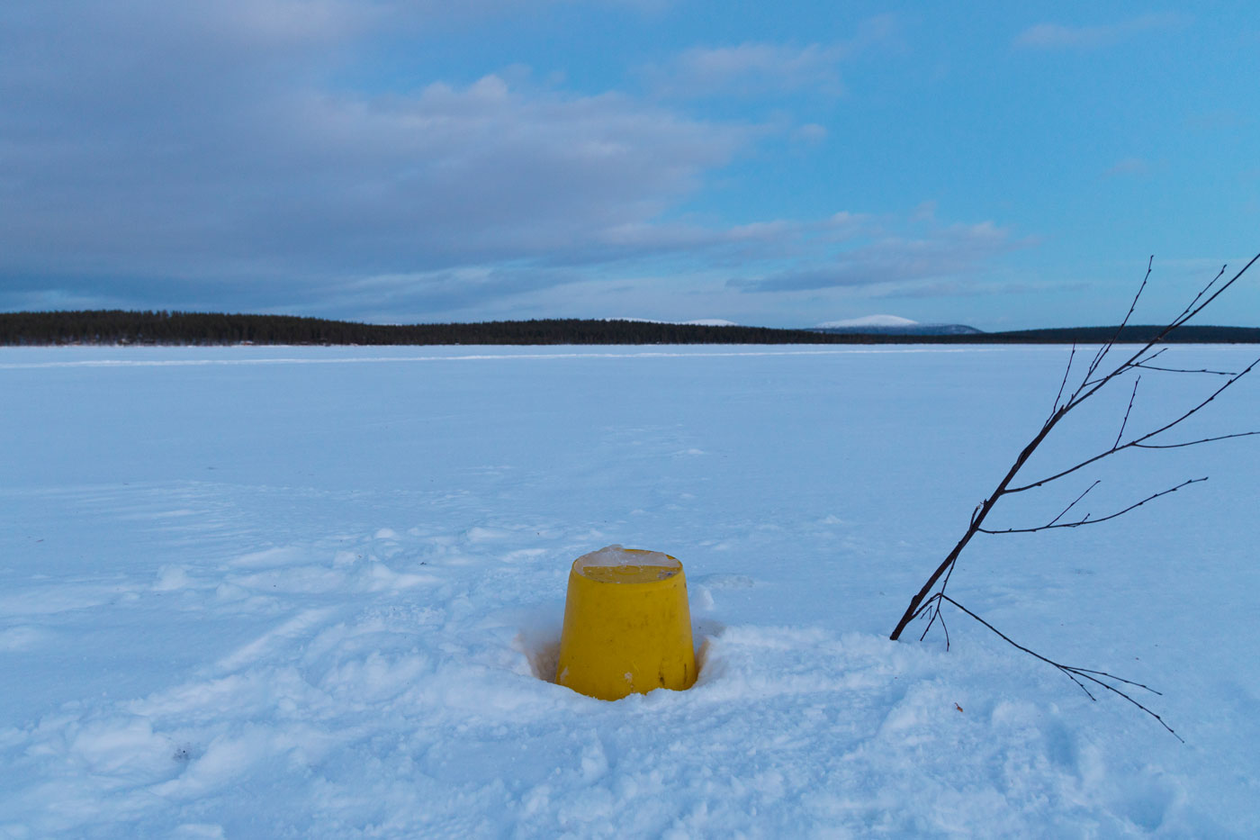Ein Eimer markiert das Loch im Fluss, um Wasser zu holen